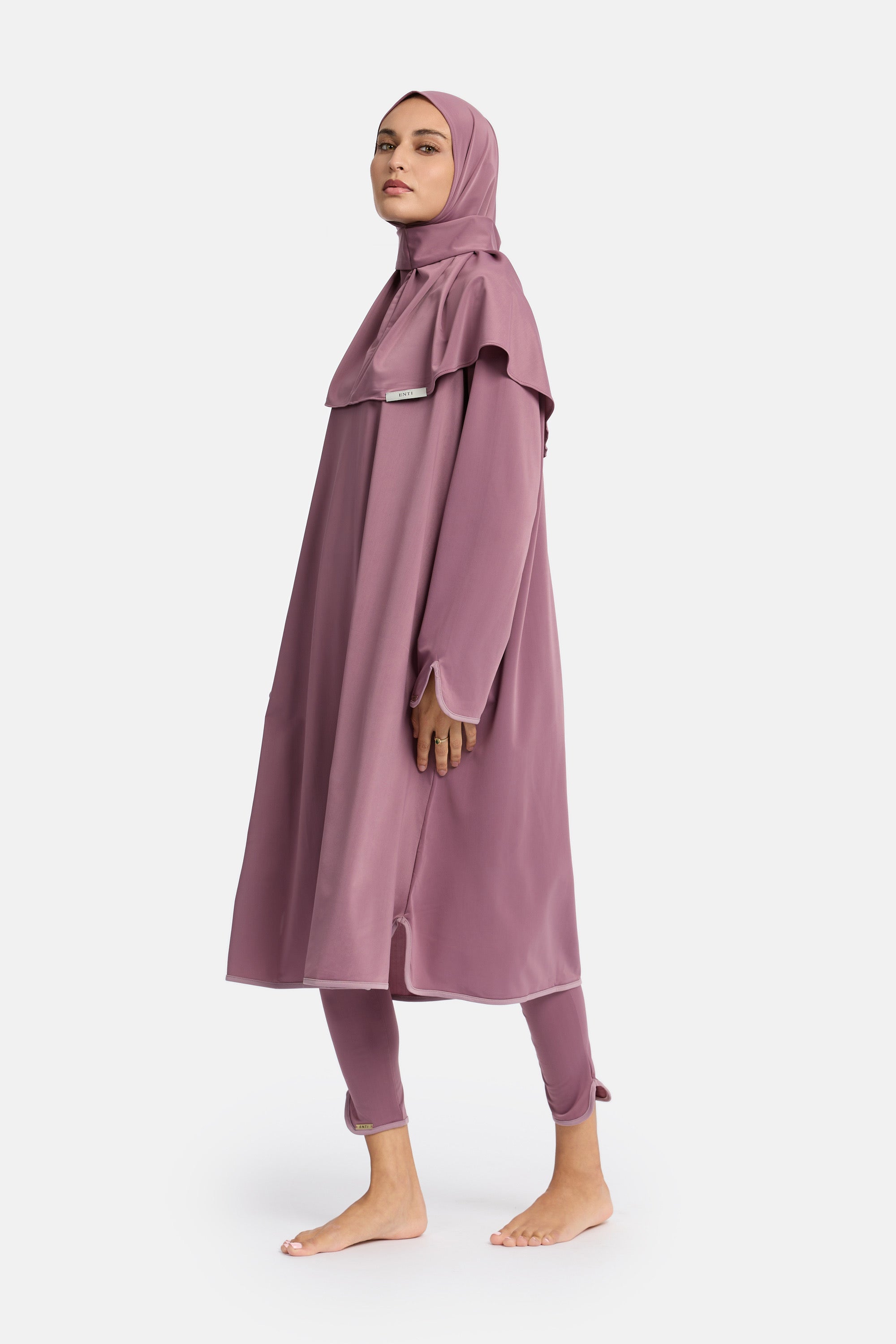 zij aanzicht van model die de modest burkini van het merk enti draag met de zwemjurk en instant swim hijab in de kleur old pink