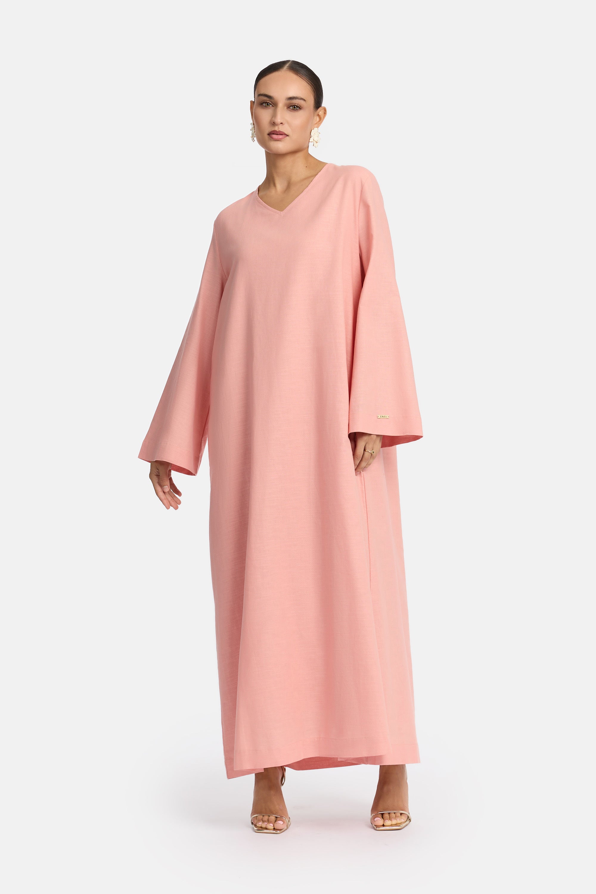 voor aanzicht van Model die draagt een modest linen loose dress van het merk enti in de kleur pastel pink