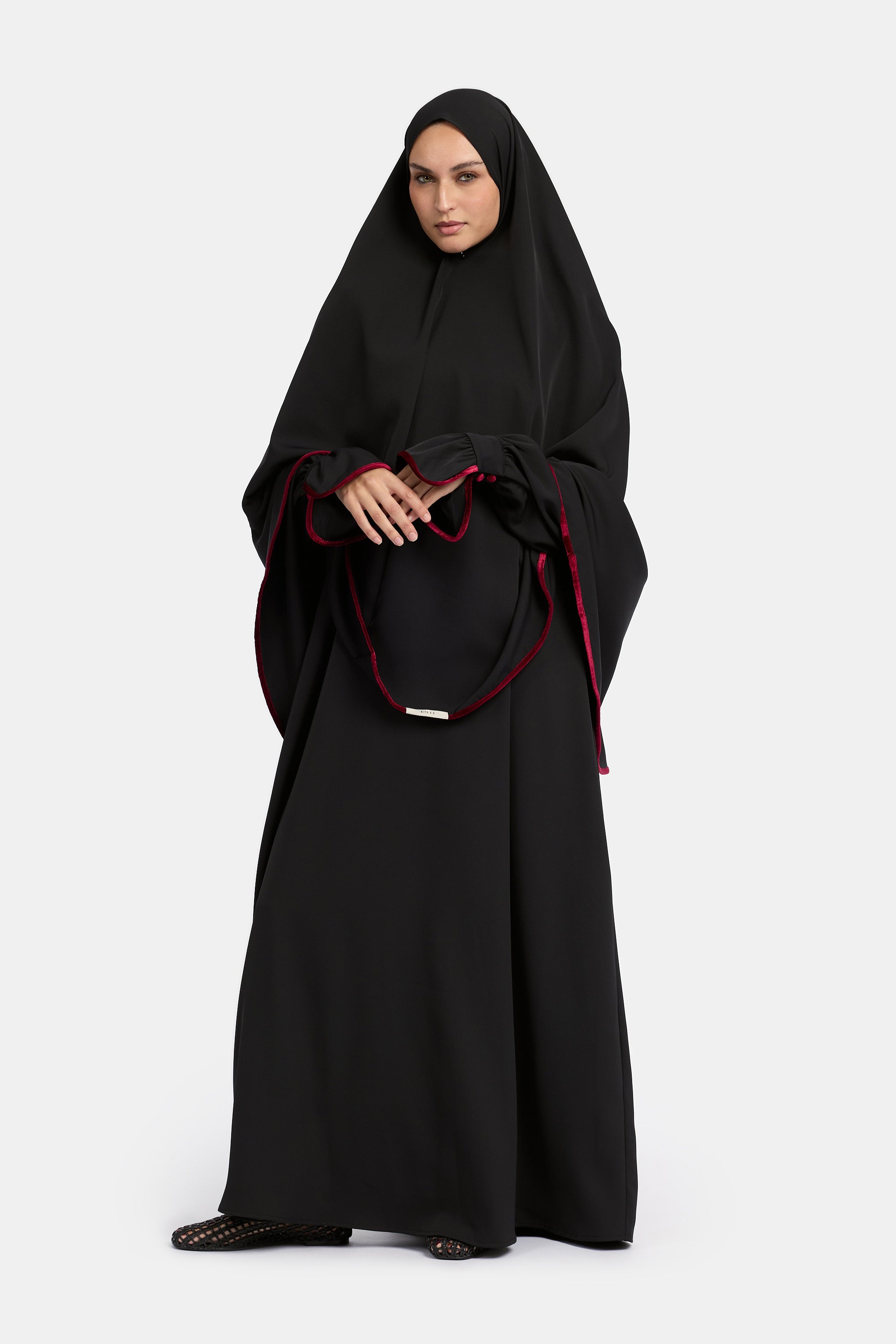 voor aanzicht van model die draagt de mastour velvet khimar en abaya set in de kleur zwart.
