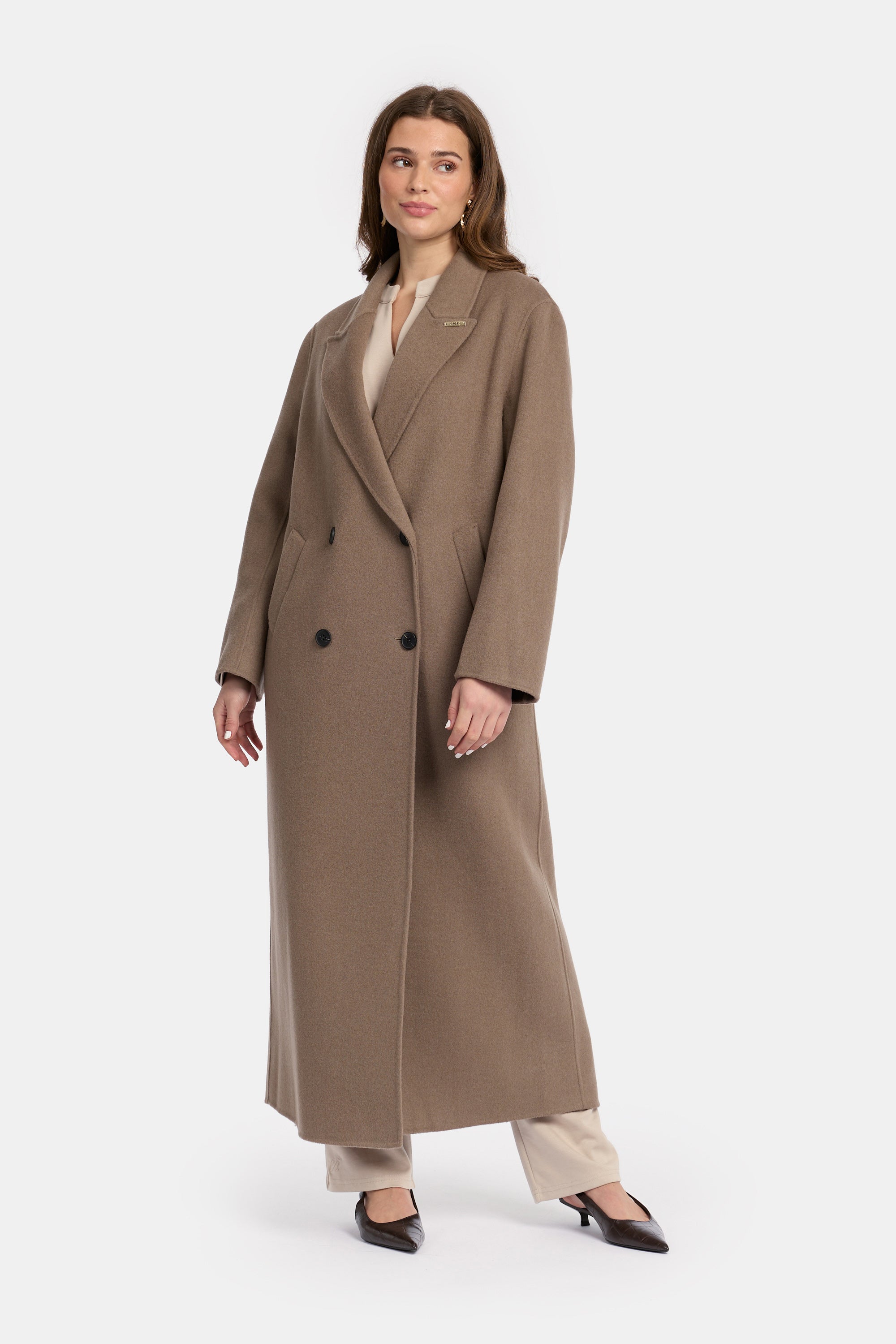 model draagt de wollen jas van het modest merk enti in de kleur bruin