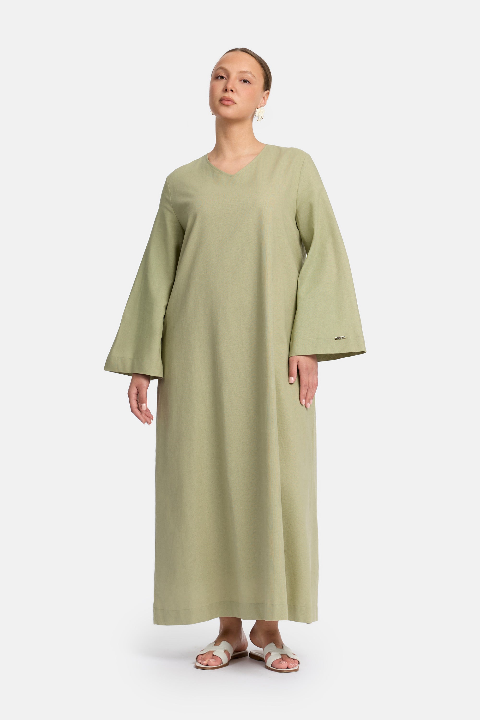 voor aanzicht van Model die draagt een modest linen loose dress van het merk enti in de kleur pastel green