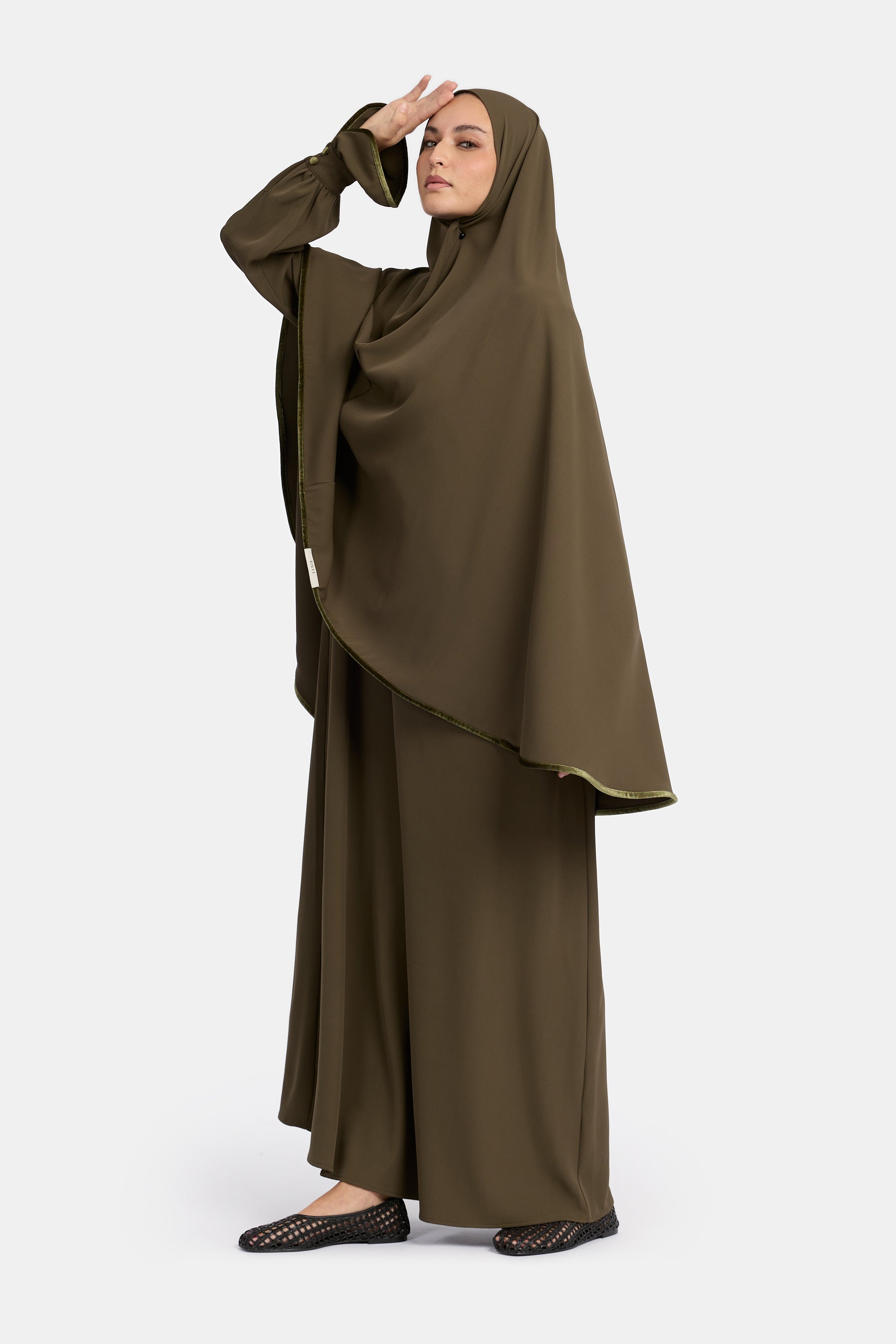 zij aanzicht van model die draagt de mastour velvet khimar en abaya set in de kleur groen.