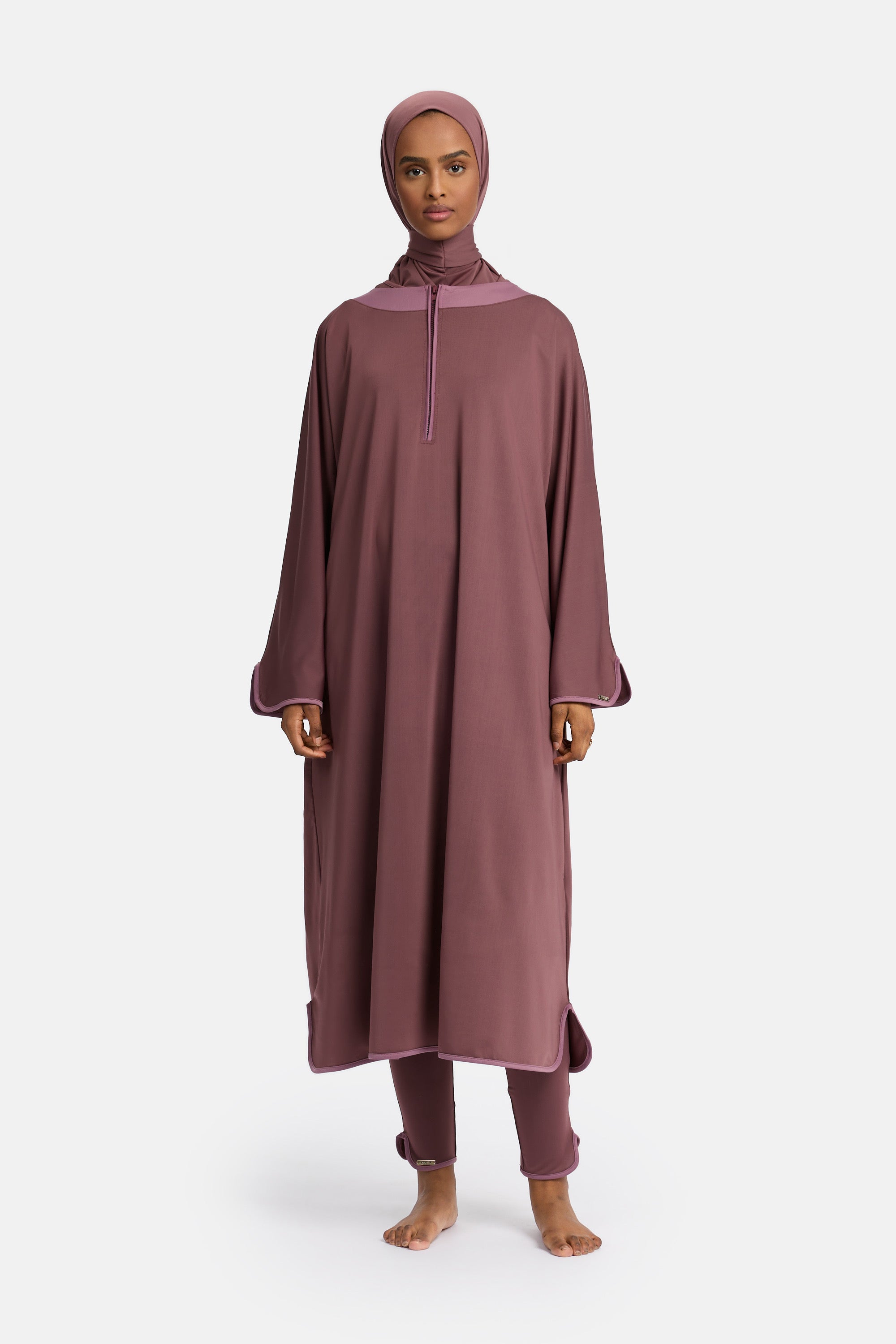 Voor aanzicht van model die de modest burkini van het merk enti draag met de coverup jurk in de kleur aubergine purple