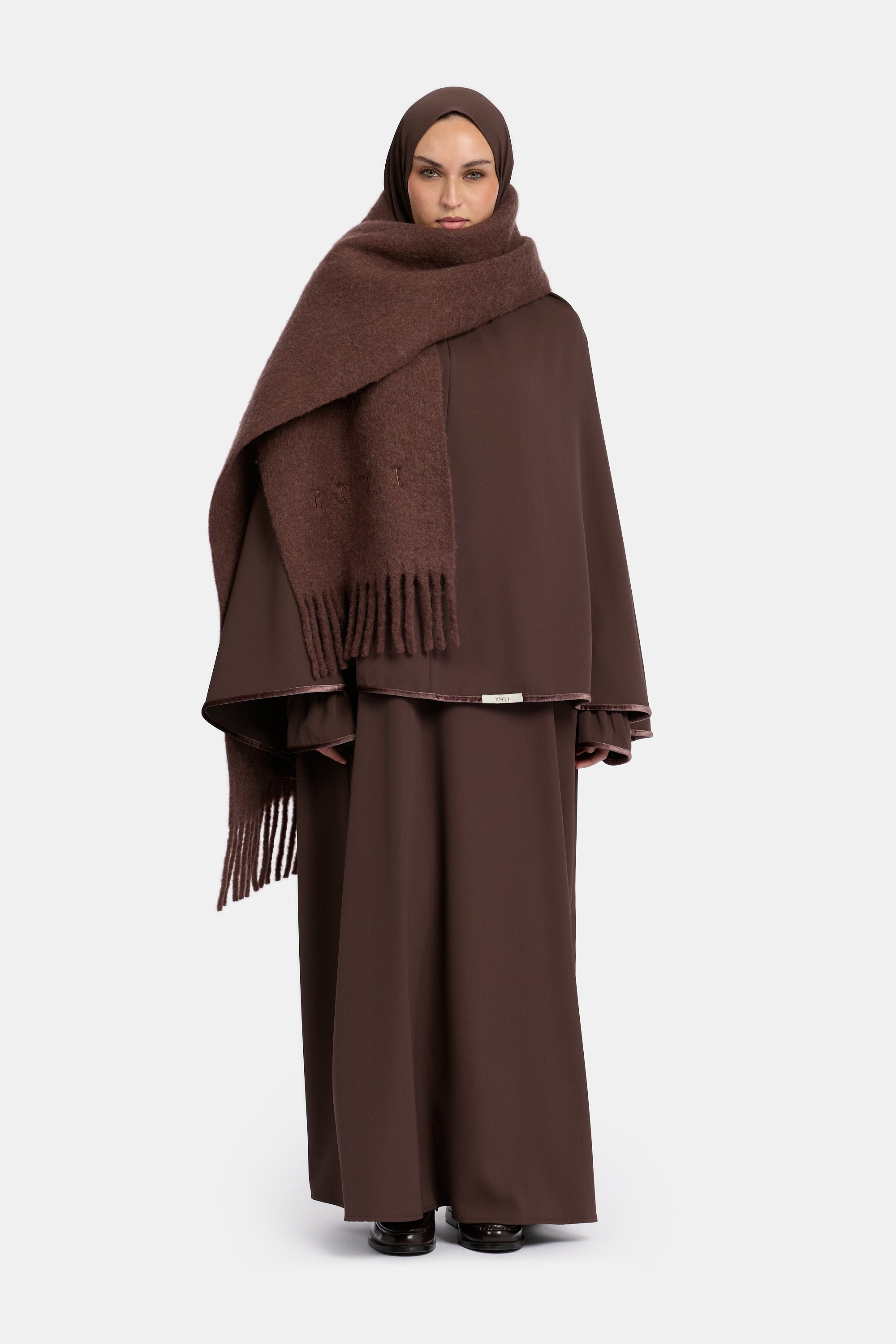 voor aanzicht van model die draagt de mastour velvet khimar en abaya set in de kleur donker bruin met de enti wool scarf.