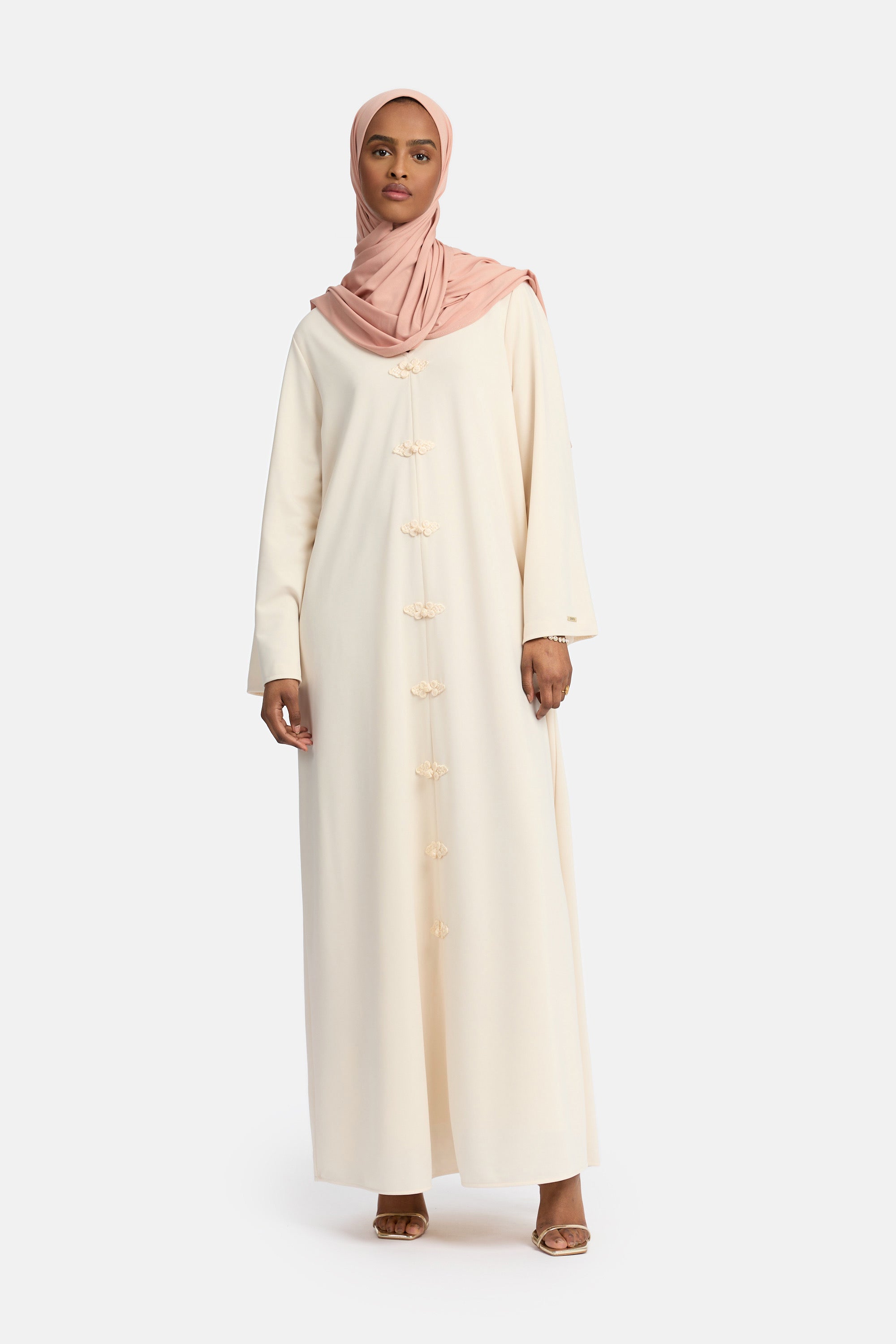 voor aanzicht van Model die draagt een modest kaftan dress van het merk enti in de kleur beige