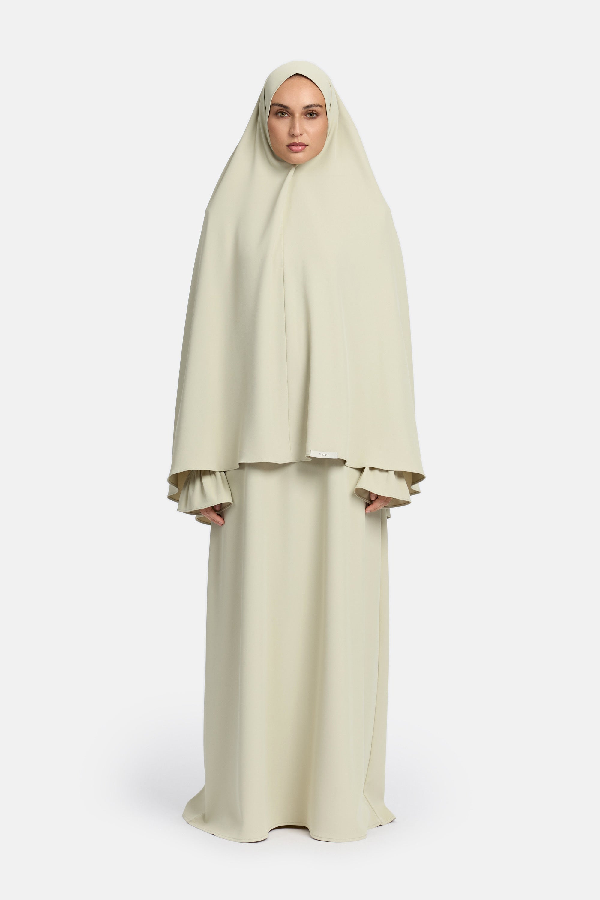 voor aanzicht van model die mastour set abaya en khimaar draagt van het merk ENTI in de kleur licht groen