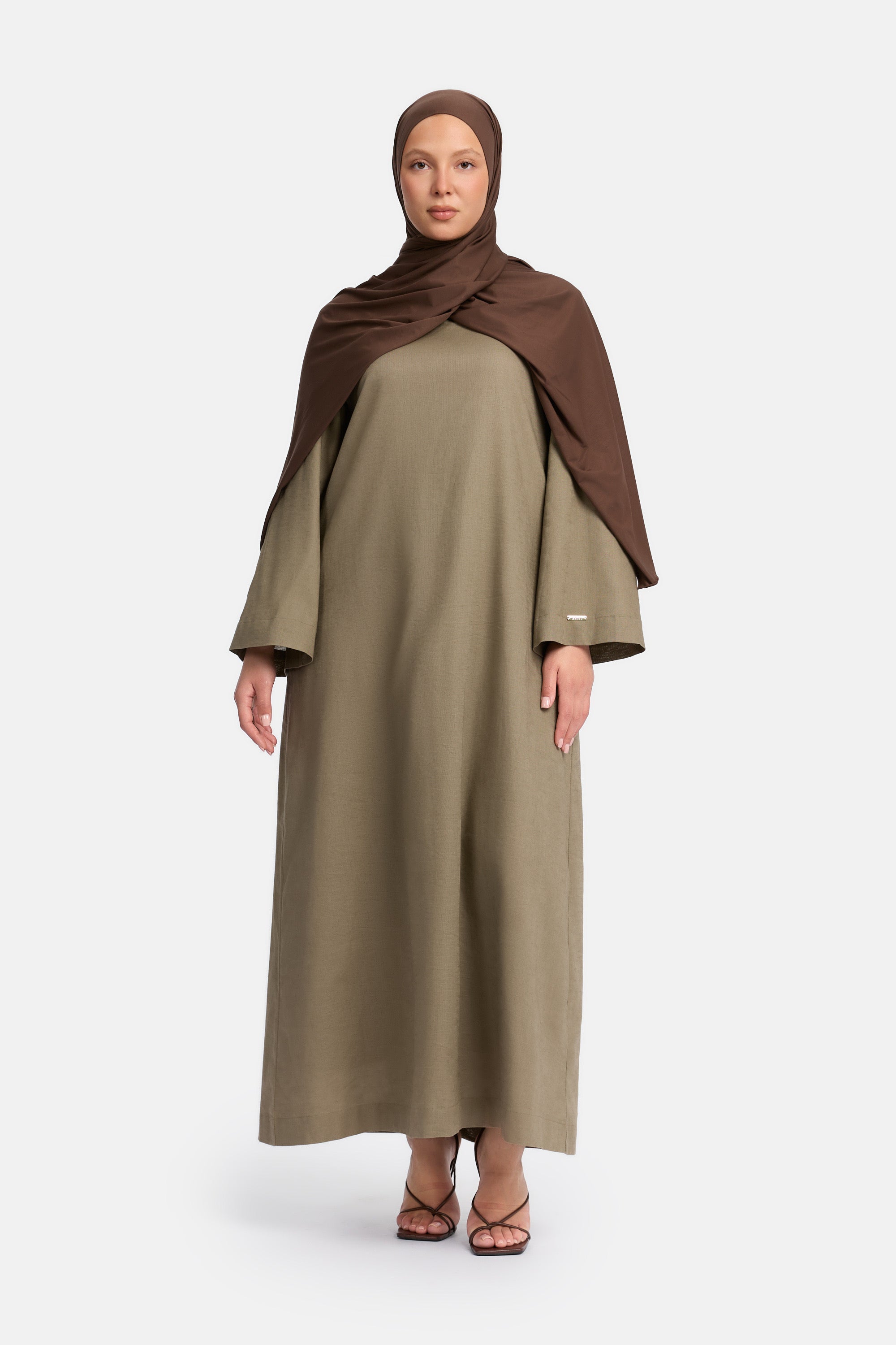 voor aanzicht van Model die draagt een modest linen loose dress van het merk enti in de kleur Ash brown