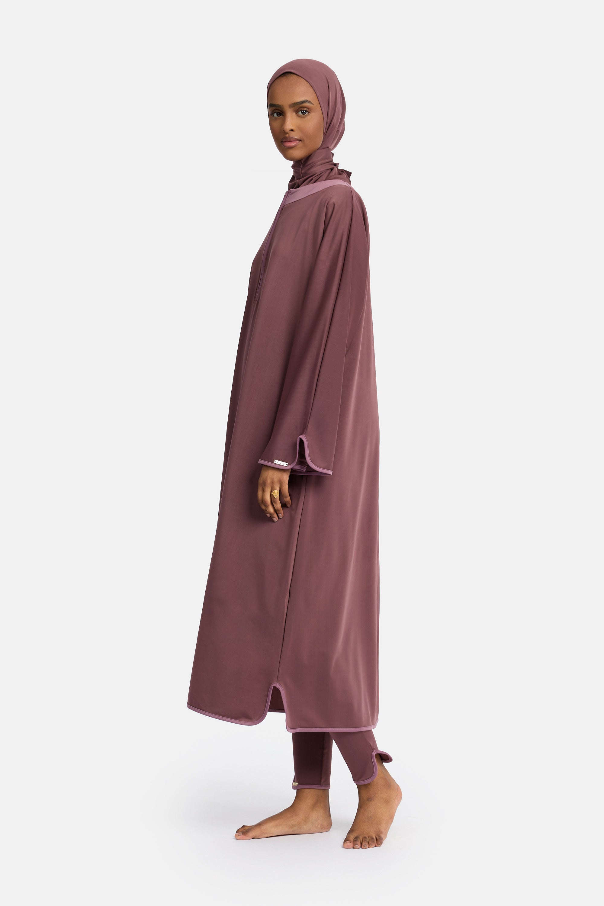 zij aanzicht van model die de modest burkini van het merk enti draag met de coverup jurk in de kleur aubergine purple