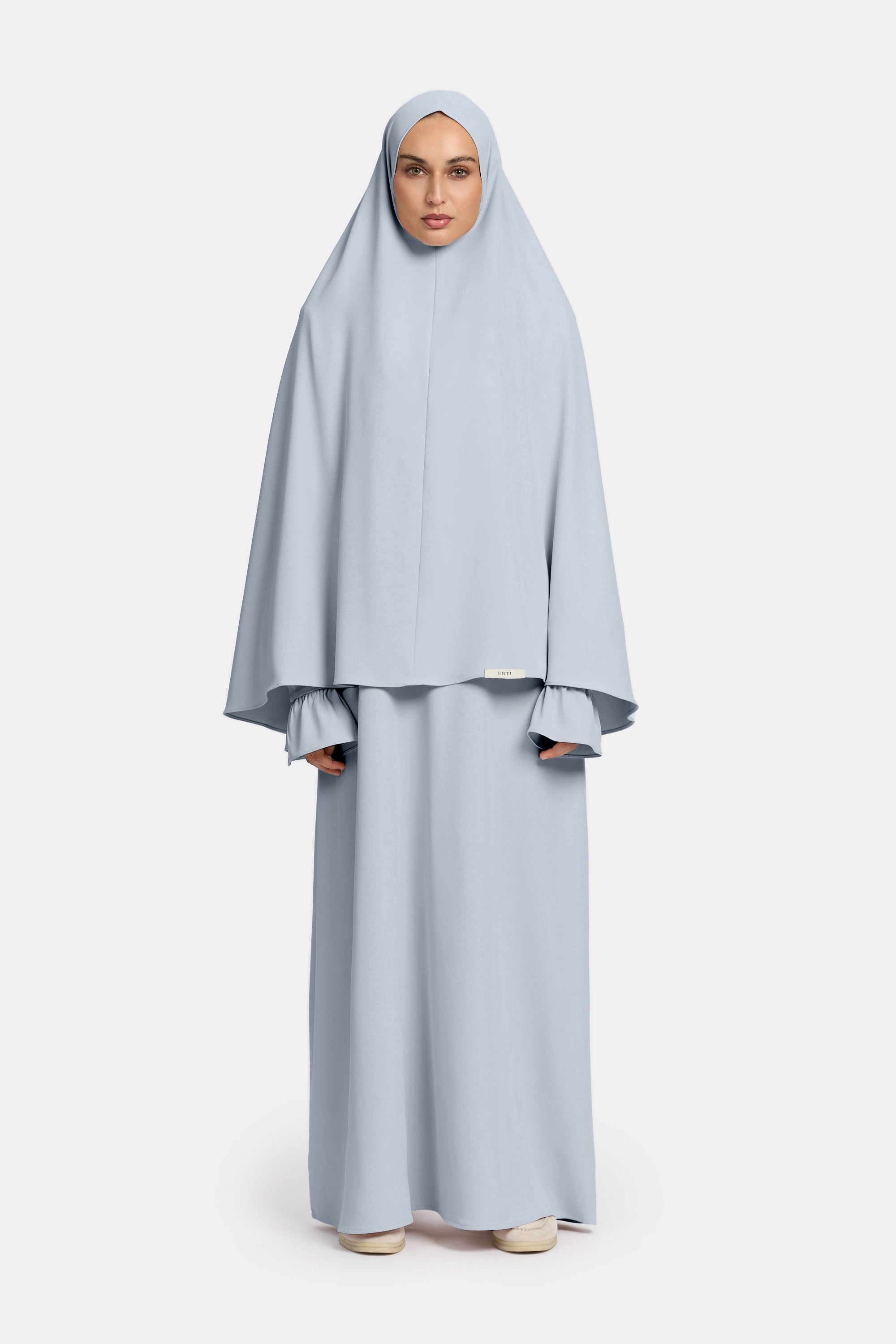 voor aanzicht van model die mastour set abaya en khimaar draagt van het merk ENTI in de kleur blauw
