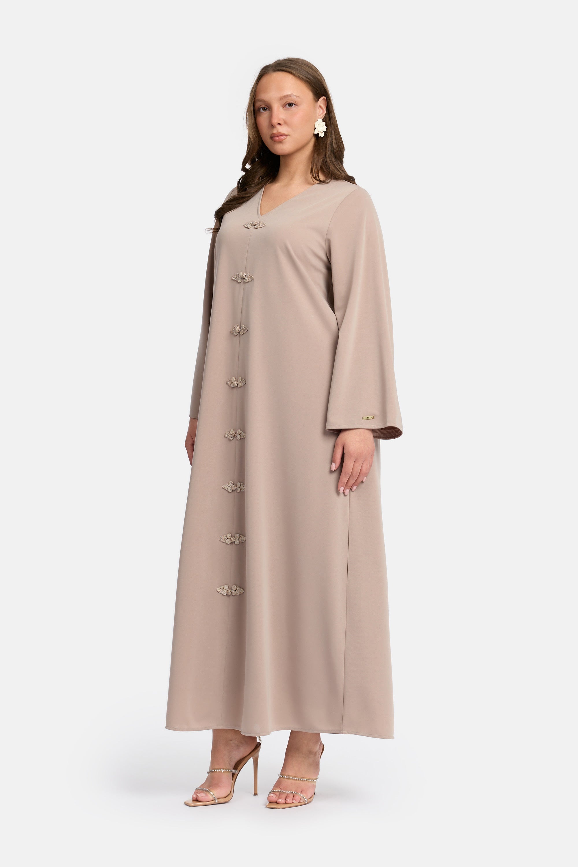 zij aanzicht van Model die draagt een modest kaftan dress van het merk enti in de kleur ash brown  