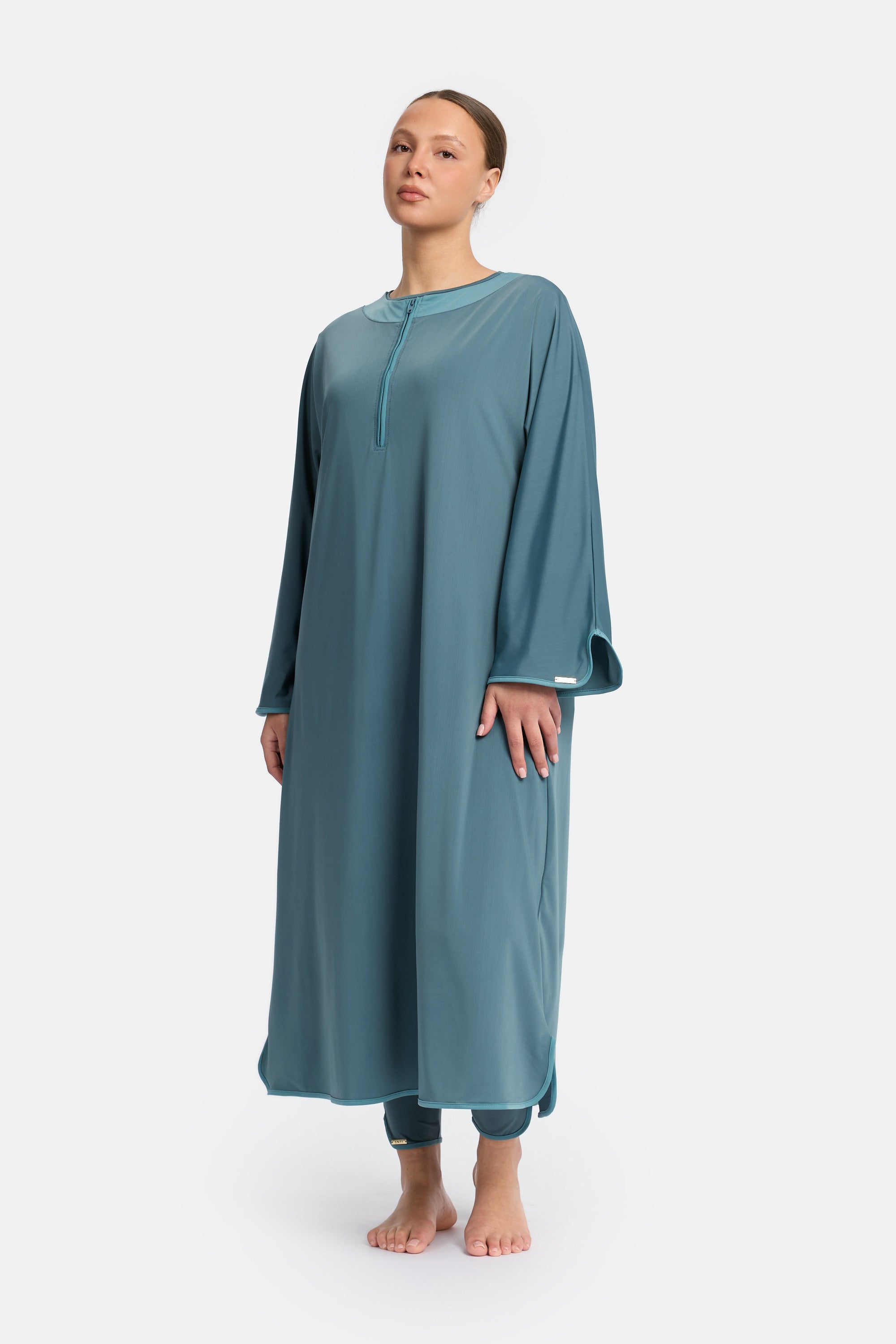 Voor aanzicht van model die de modest burkini van het merk enti draag met de coverup jurk in de kleur Turquoise Blue

