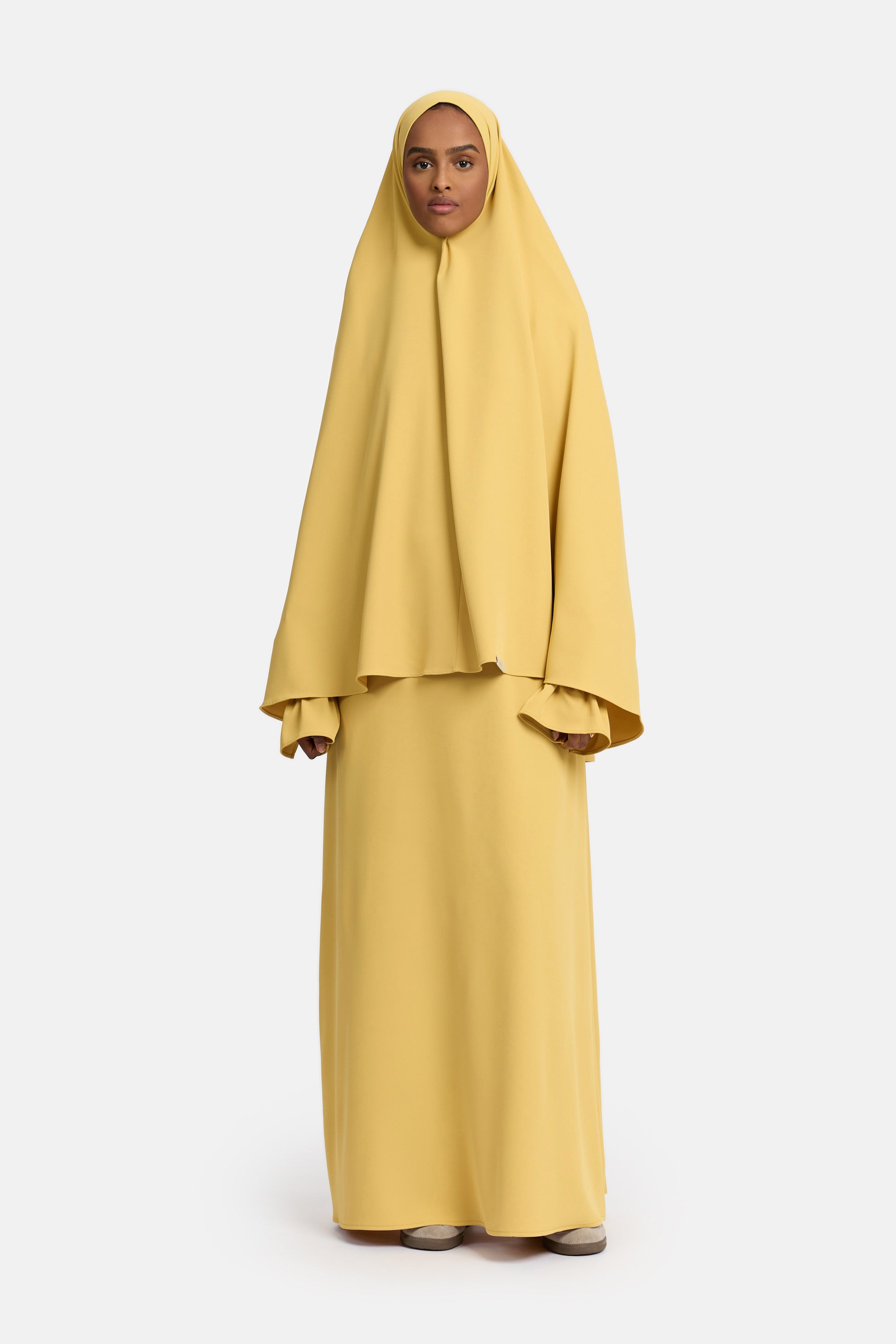 voor aanzicht van model die mastour set abaya en khimaar draagt van het merk ENTI in de kleur Geel