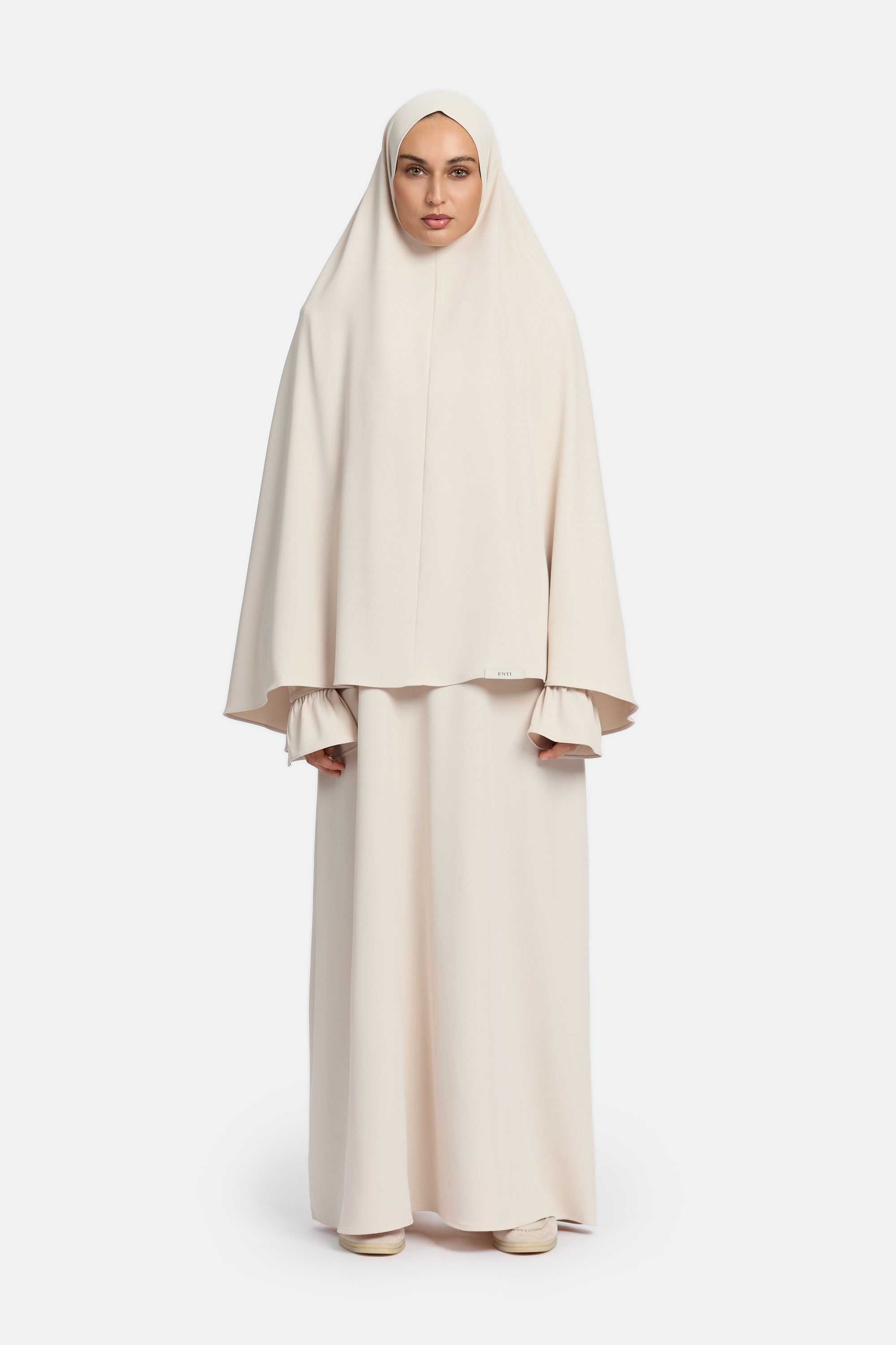 voor aanzicht van model die mastour set abaya en khimaar draagt van het merk ENTI in de kleur beige