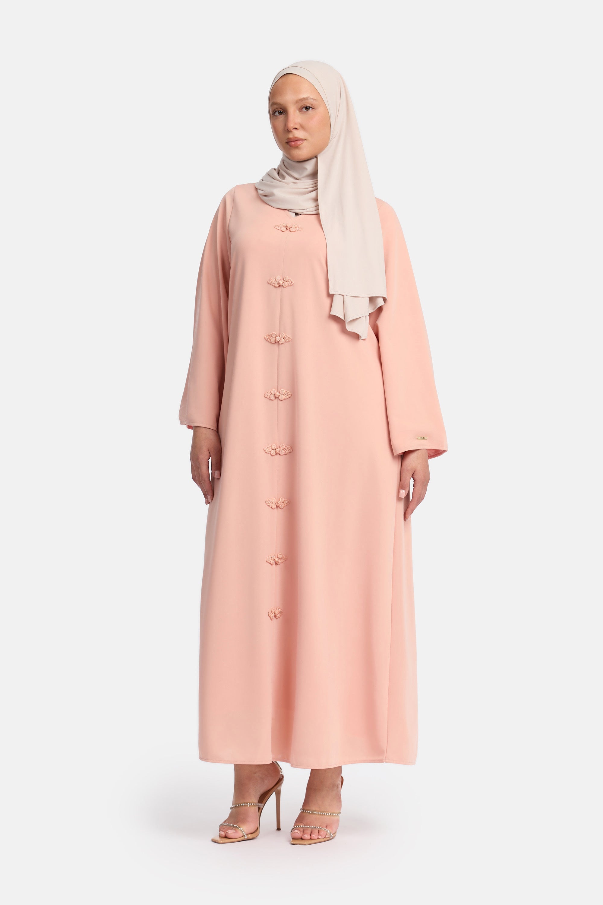 voor aanzicht van Model die draagt een modest kaftan dress van het merk enti in de kleur pastel roze