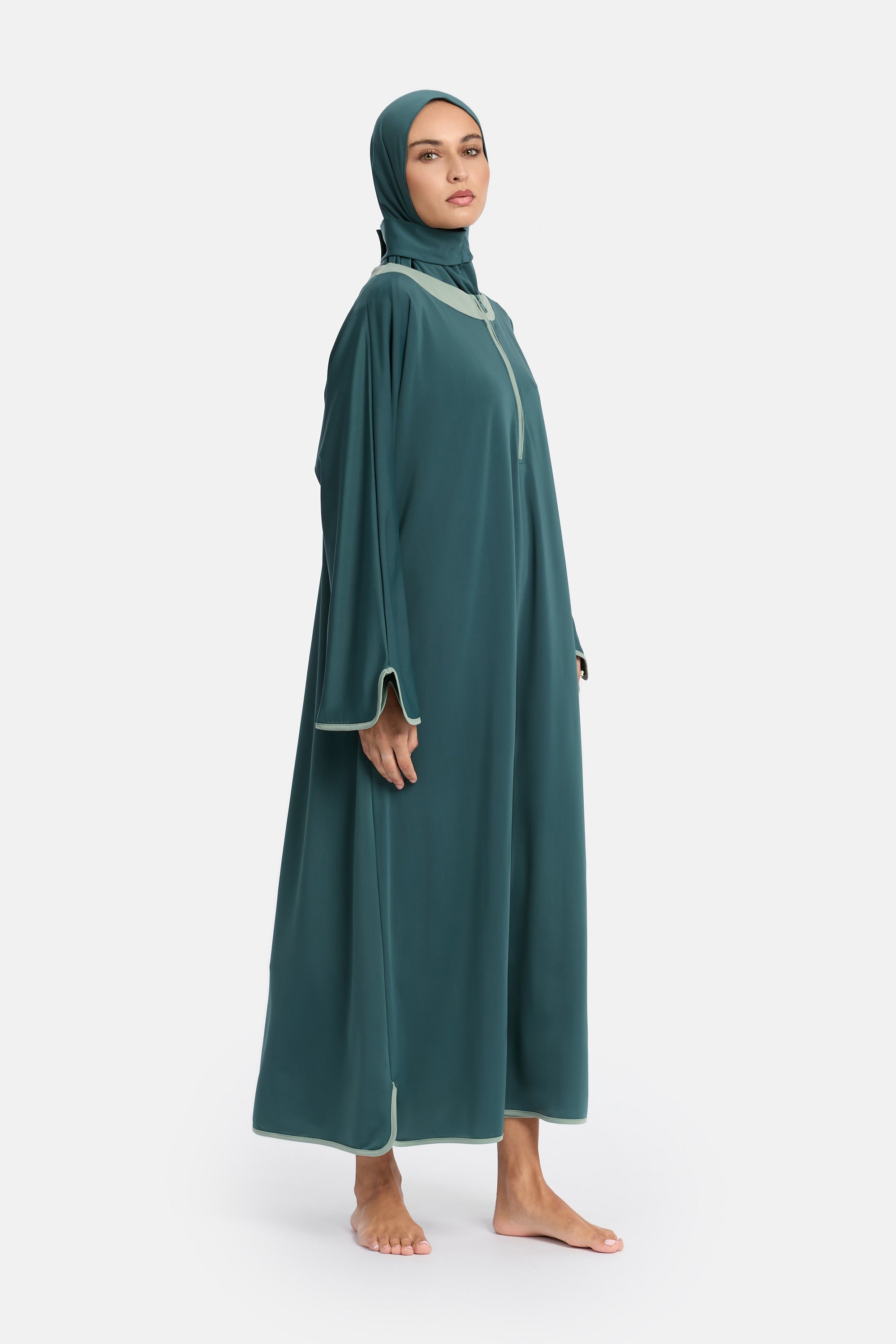 zij aanzicht van model die de modest burkini van het merk enti draag met de coverup jurk en instant swim hijab in de kleur minty green
